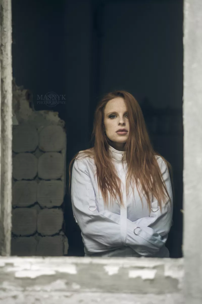 Redhead in straitjacket bondage by window